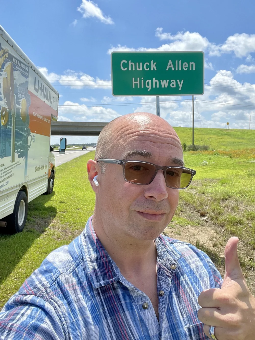 Chuck beside the Chuck Allen Highway sign on the trip home