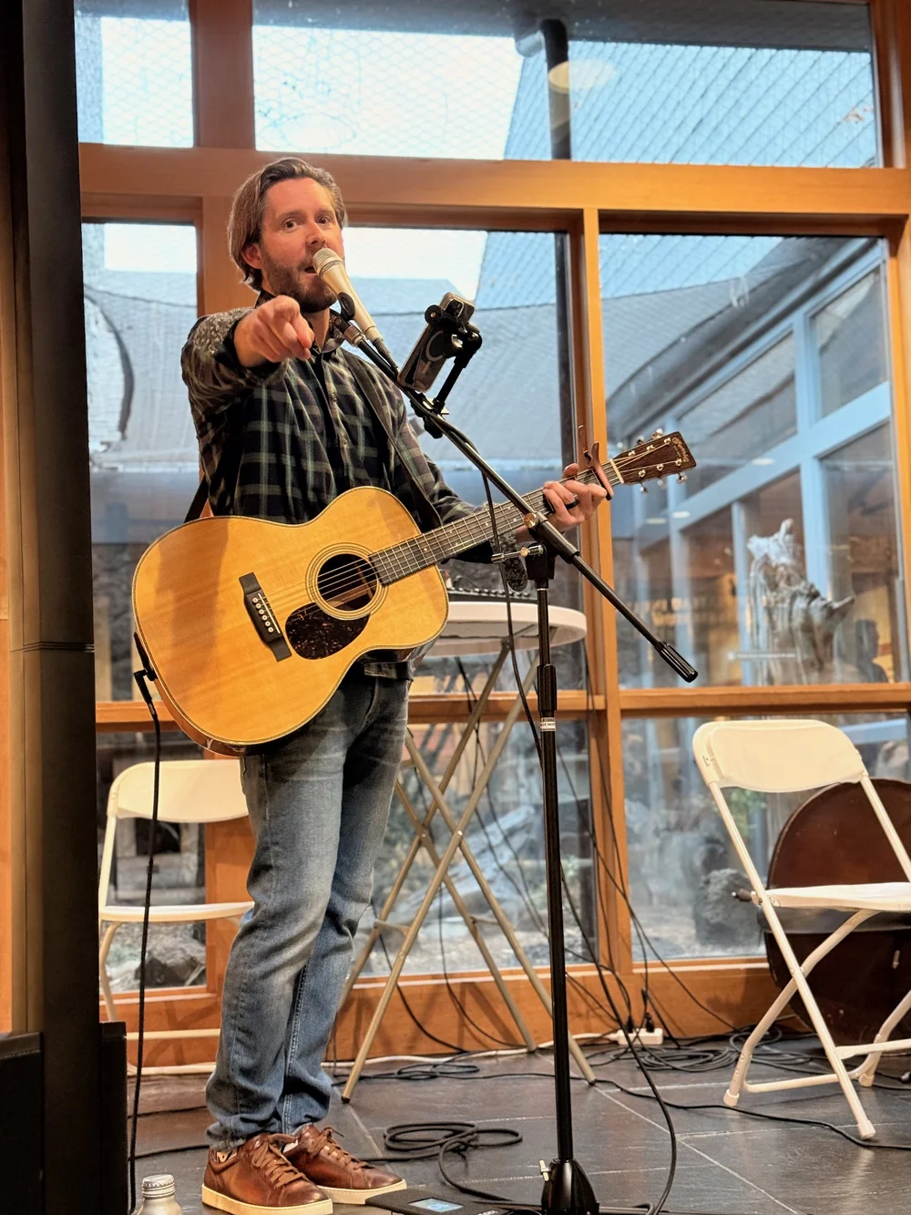 An acoustic guitarist performing with a microphone